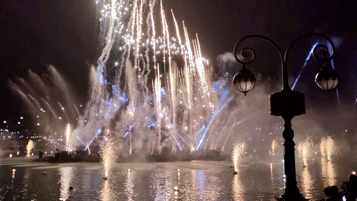 Disney Cascade of Lights nighttime show over Adventure Bay lake, with drones and water projections